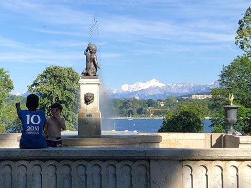 Kids playing in a fountain at La Perle du Lac. Behind them we can spot the Geneva Lake and the Mont-Blanc mountain.