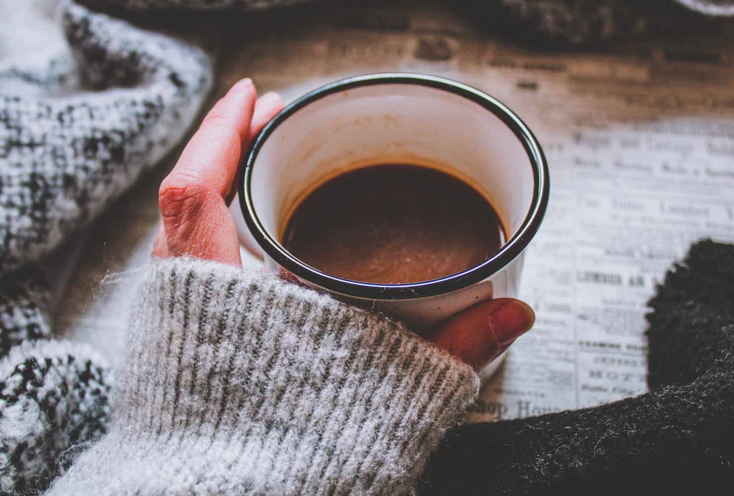 Hand holding a warm cup of coffee