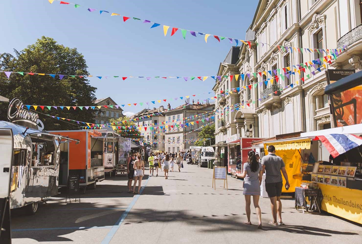 view of a street food festival in geneva with many foodtrucks 