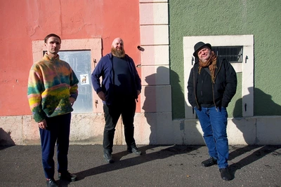 3 personnes devant un mur coloré