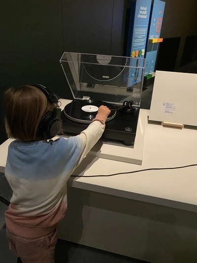 Photo d'un enfant qui écoute une oeuvre sonore dans l'exposition Afrosonica - Paysages sonores au MEG
