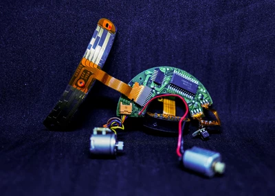 Sur un fond foncé de couleur jeans, un circuit électronique est posé. Il ressemble à une bestiole.