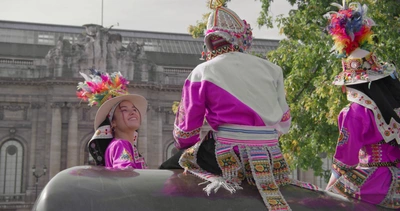 Trois jeunes personnes en tenue traditionnelle bolivienne se font face devant le Musée d'art et d'histoire de Genève