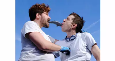 Les deux interprètes mangent un faux poisson