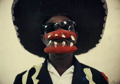 La photographie montre le visage de la figure de la troupe de carnaval Chaloska, général sanguinaire, avec une énorme mâchoire en papier mâché et parée de dents.
