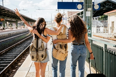 Trois jeunes femmes à la gare pour prendre le train pour leurs vacances