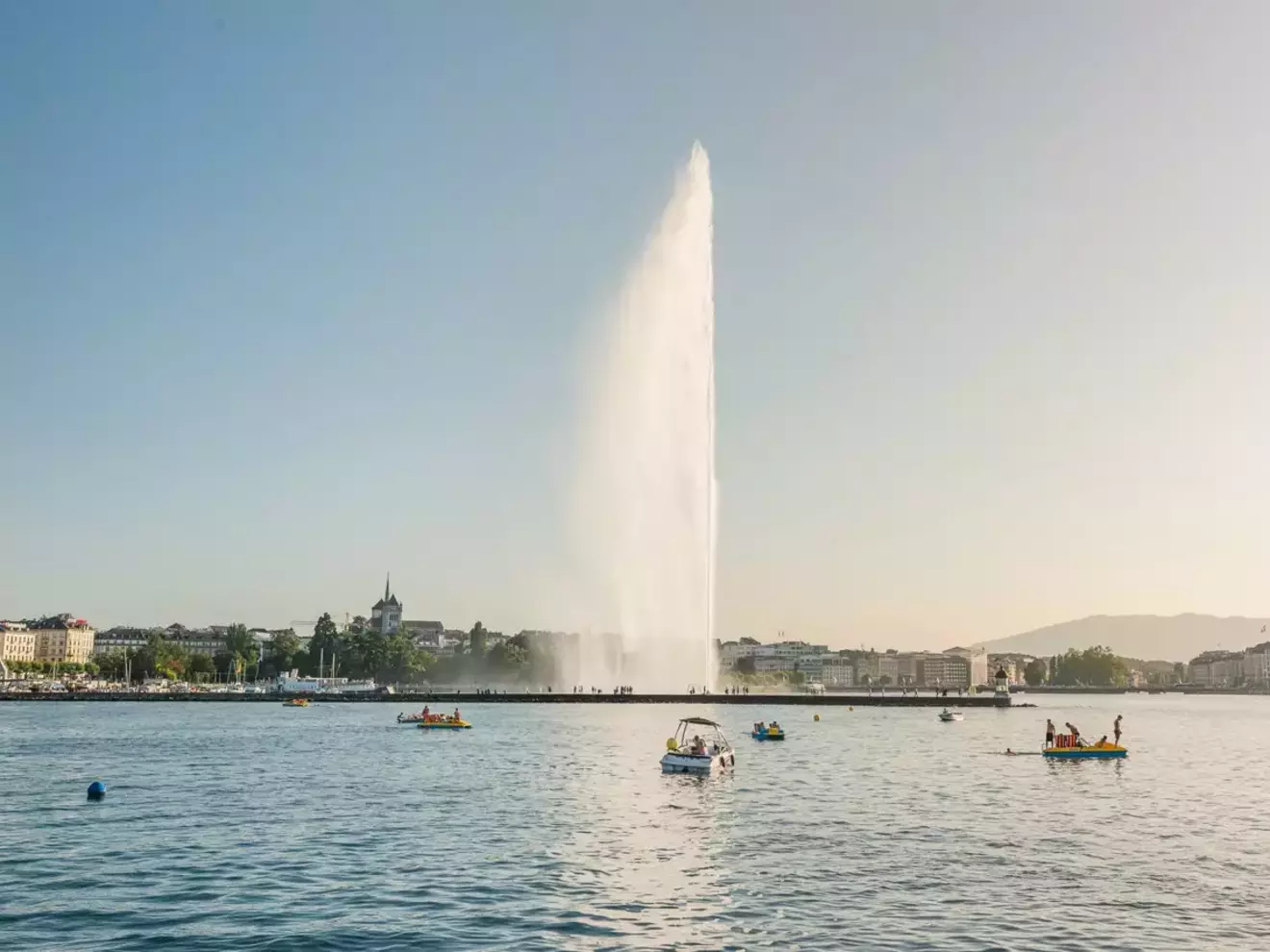 Jet d’Eau s’élevant au-dessus du lac Léman avec des bateaux sur l’eau