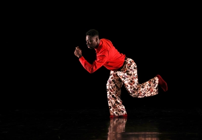 MEG x Groove’N’Move : Atelier Afro Danseur de danse afro en train de faire un mouvement de danse devant un fond noir.