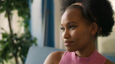 Une jeune femme souriant légèrement et regardant vers la gauche.