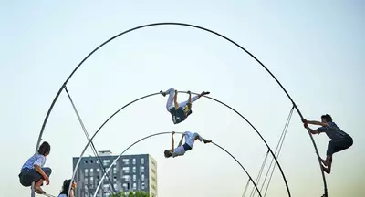 Sur l'image, il y a 4 personnes se tenant ou se suspendant à une spirale d'une hauteur de 7 mètres.