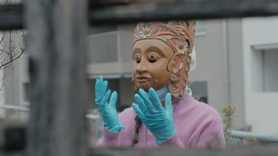 Une femme portant un masque ethnique et des gants jetables.