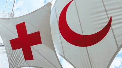 Deux grands drapeaux, l'un avec une croix rouge et l'autre un croissant rouge sur fond blanc