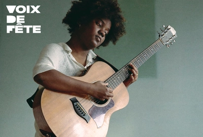 une photo de l'artiste jouant de la guitare