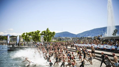 La Tour Triatlon Cette image montre le départ impressionnant du Triathlon de Genève.
On voit une foule d'athlètes se jeter dans le lac Léman.