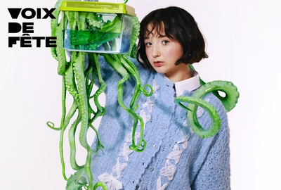 Une image représentant l'artiste tenant un aquarium avec une pieuvre verte