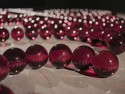 Le verre, une matière mystérieuse Œuvre de BYARS James Lee. Il s'agit d'une installation d'une multitude de boules rouge en verre mises les unes à côté des autres pour former des arabesques.