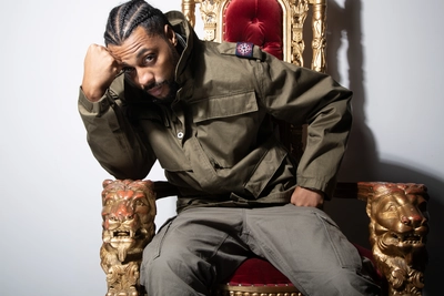 Une photo de l'artiste assit sur un trône