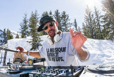 Un portrait de Dj Greens en train de mixer en station de sports d'hiver.