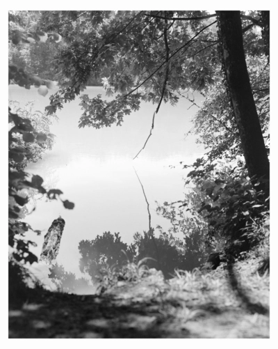 Massao Mascaro. Ici, là (Here, There) Photographie en noir et blanc du Rhône vu depuis la rive, avec de la végétation au premier plan