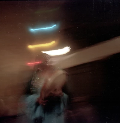 Femme dansant et jouant d'un instrument, la photo est un peu floue pour évoquer le mouvement.