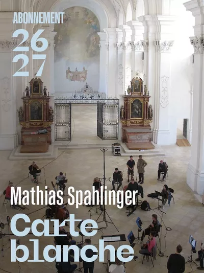 Carte blanche L’image montre un grand intérieur d’église baroque, lumineux et décoré de fresques et de sculptures. C'est l'Abbatiale de Bellelay. Au centre, des musiciens sont installés pour un concert, avec le texte « Mathias Spahlinger – Carte blanche » au premier plan.