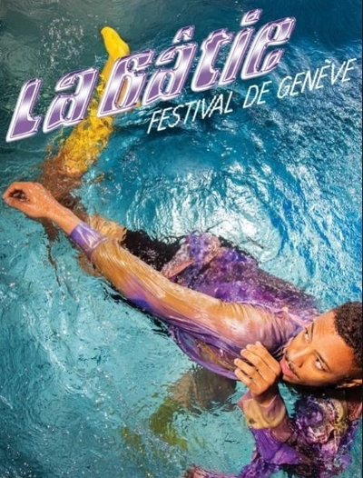 L'image montre un homme immergé dans une eau de piscine d'un bleu. Il porte une chemise aux nuances violettes, lilas et jaunes.