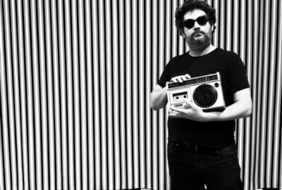 Mr HOBBS · ALL STYLE POP Une photo en noir et blanc : fond rayé et Mr Hobbs avec des lunettes noires et un lecteur de cassettes des années 80.