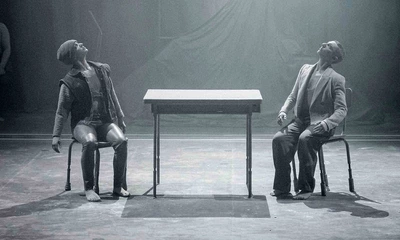 Sur cette image, on peut voir deux avatars assis sur une chaise chacun à une extrémité d'une table