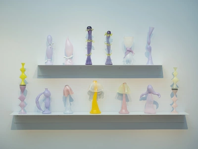 Vue de l'exposition : on y voit des vases en verre aux couleurs pastels