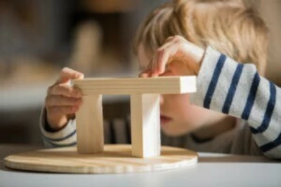 Enfant devant un jouet en bois