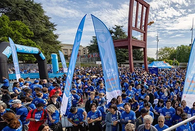 foule en bleu devant une immense chaise en bois sur une place