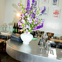 A bar counter decorated with flowers at an Art Tables restaurant in Geneva