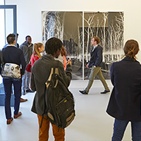 Visitors admiring an art installation during a guided gallery tour in Geneva's Quartier des Bains